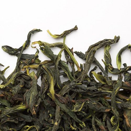 Close-up texture of Huiming Tea leaves, showing fine hand-rolled strands and the natural sheen of pan-fired Chinese green tea