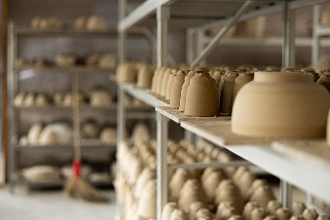 A collection of traditional chinese celadon teaware including small tea cups and celadon teapots.