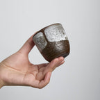 Handcrafted stoneware cup with white slip glaze overlay, wabi-sabi style ceramic teacup made from dark iron clay.