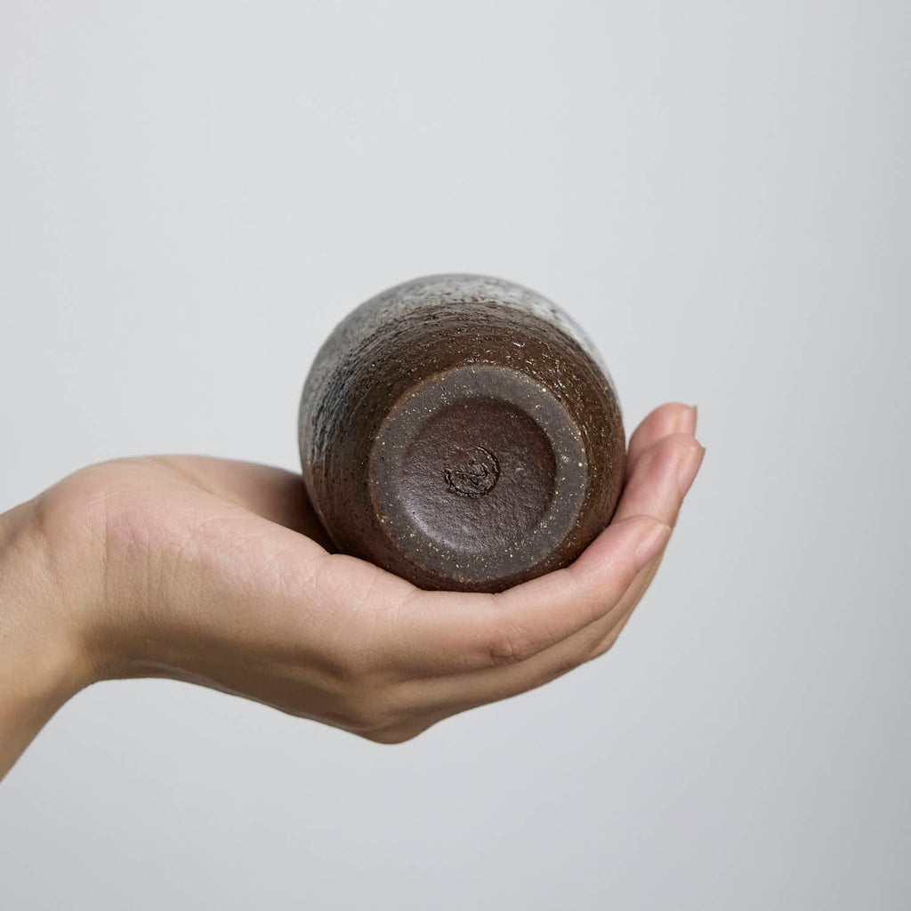 Handcrafted stoneware cup with white slip glaze overlay, wabi-sabi style ceramic teacup made from dark iron clay.