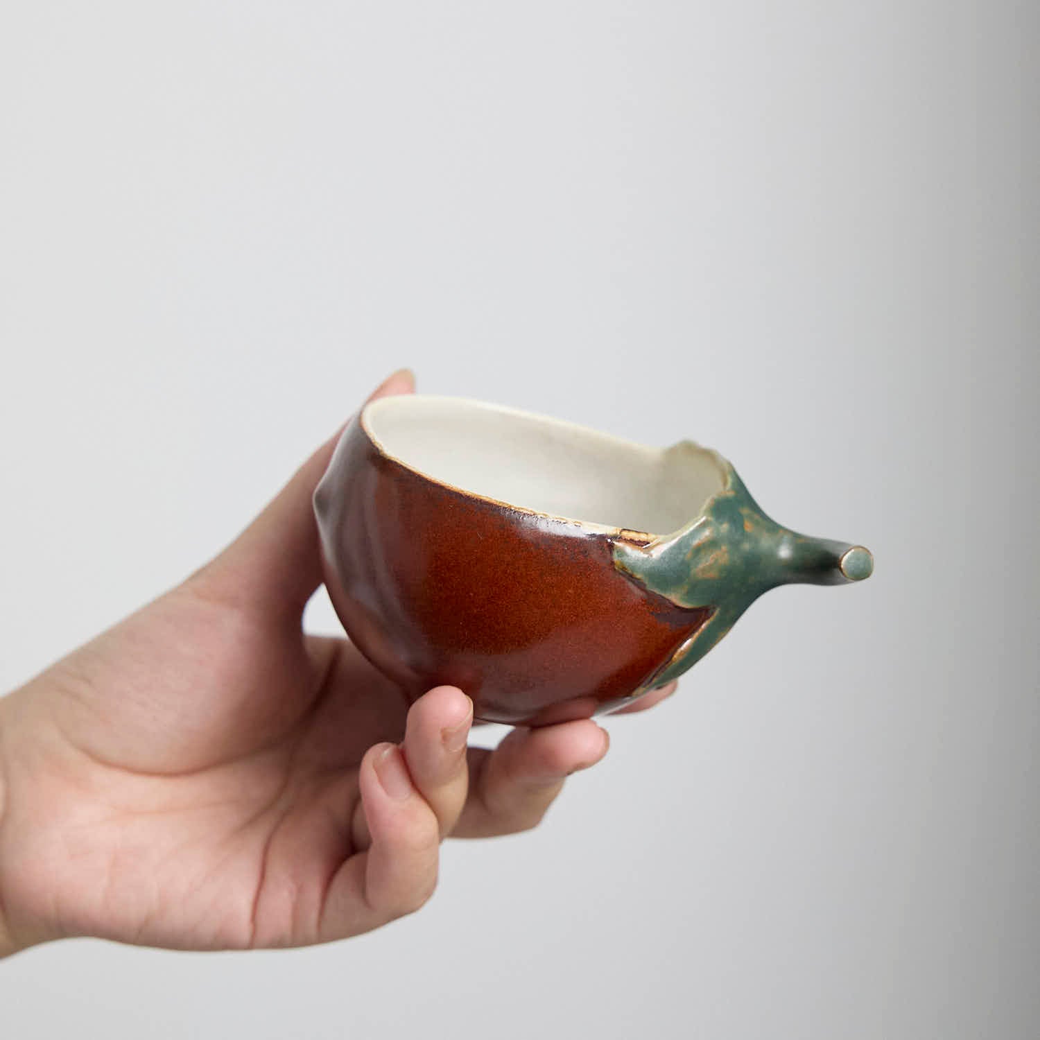 Handcrafted Hagi Ware teacup with eggplant-inspired form and natural clay texture