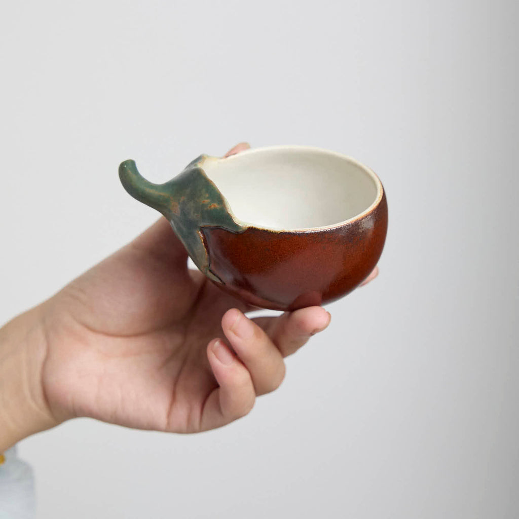 Handcrafted Hagi Ware teacup with eggplant-inspired form and natural clay texture