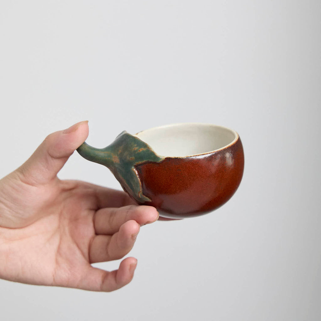 Handcrafted Hagi Ware teacup with eggplant-inspired form and natural clay texture