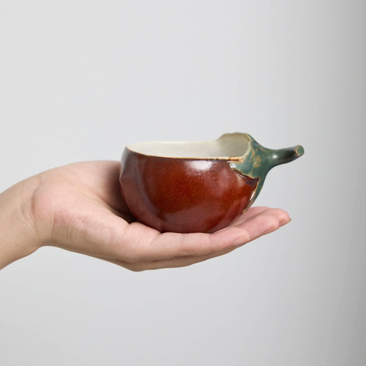 Handcrafted Hagi Ware teacup with eggplant-inspired form and natural clay texture