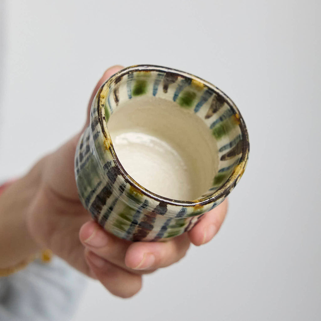 Close-up detail of the crackle glaze and striped pattern on a hand-built ceramic cup.