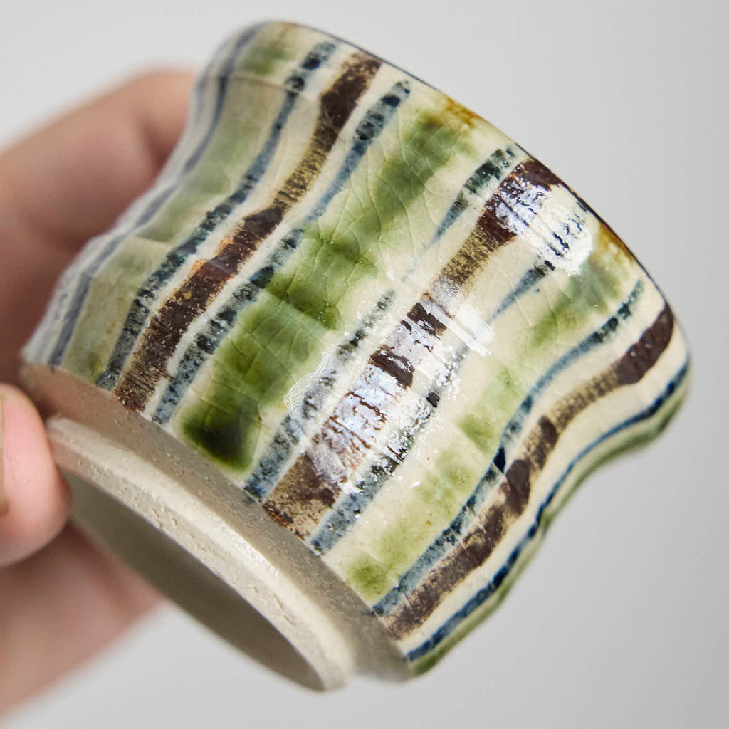 Close-up detail of the crackle glaze and striped pattern on a hand-built ceramic cup.