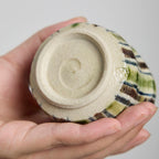 Close-up detail of the crackle glaze and striped pattern on a hand-built ceramic cup.