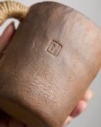 Hand-pinched rustic stoneware mug in earth tones with hemp-wrapped handle