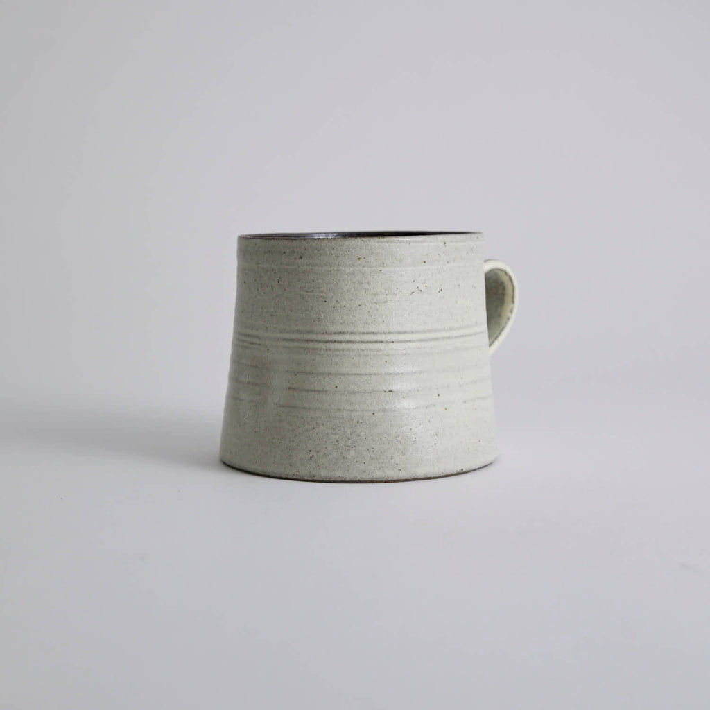 Handcrafted kiln-varied coffee cup with square rim and natural speckled texture