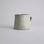 Handcrafted kiln-varied coffee cup with square rim and natural speckled texture
