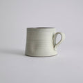 Handcrafted kiln-varied coffee cup with square rim and natural speckled texture