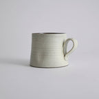 Handcrafted kiln-varied coffee cup with square rim and natural speckled texture