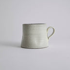 Handcrafted kiln-varied coffee cup with square rim and natural speckled texture