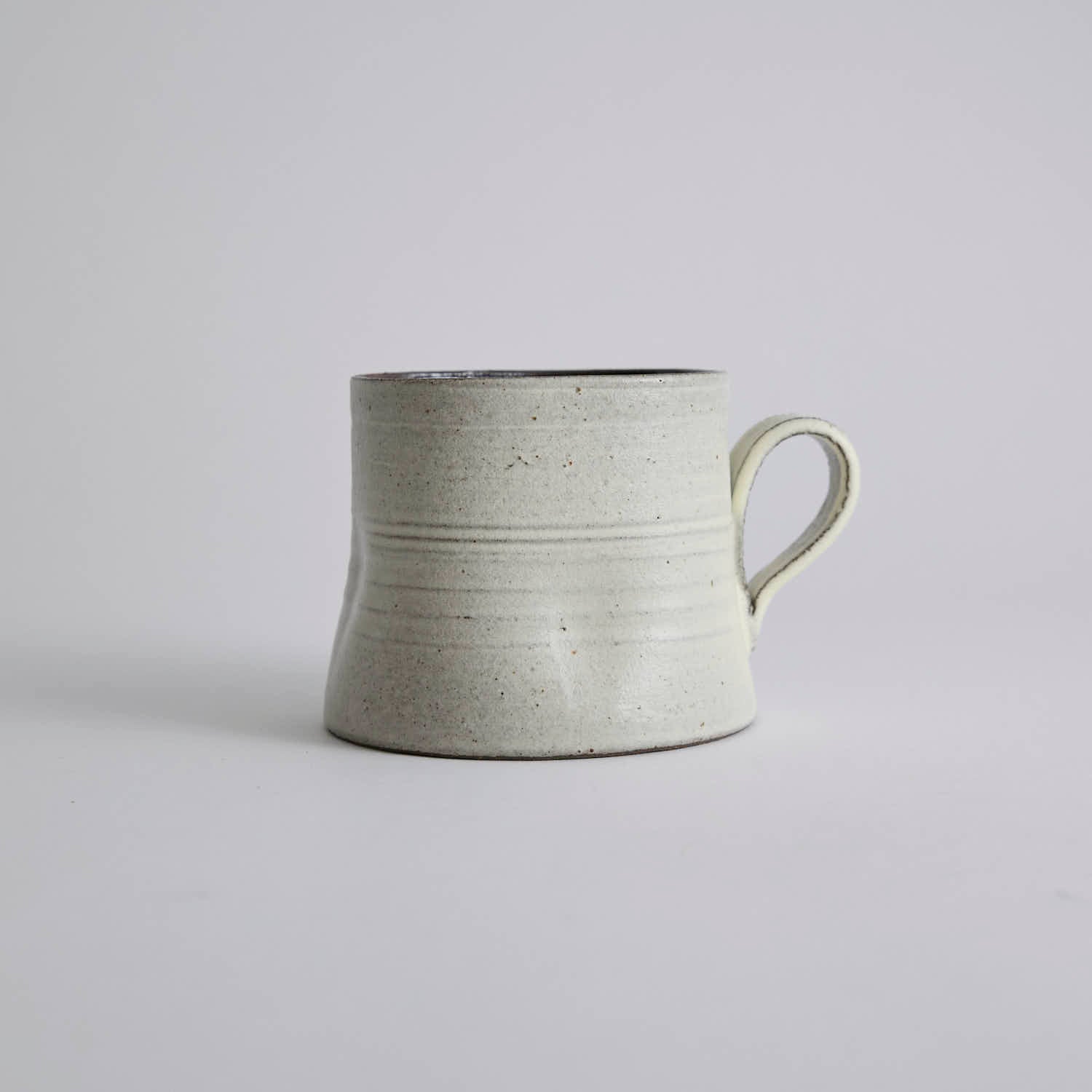 Handcrafted kiln-varied coffee cup with square rim and natural speckled texture