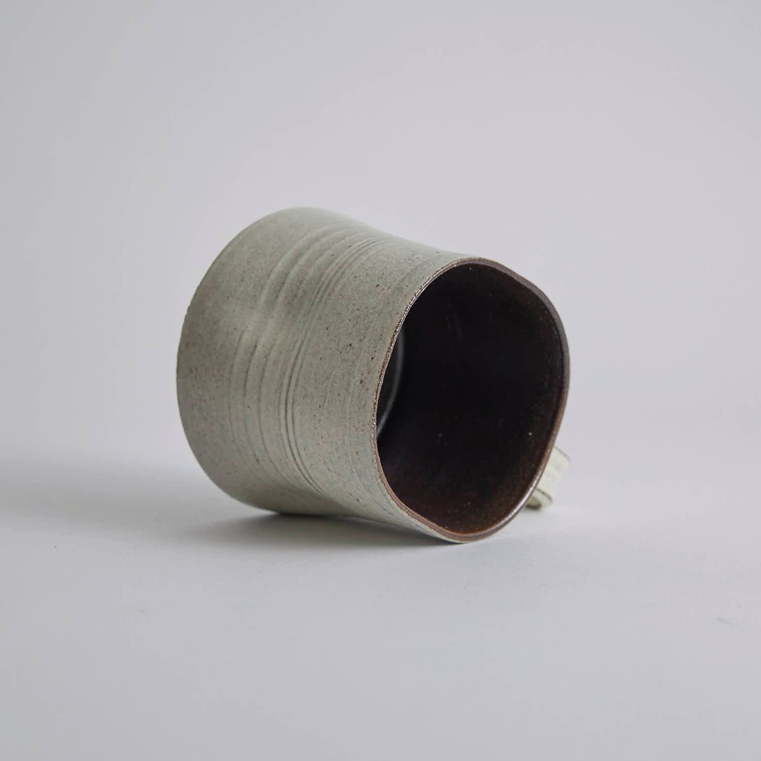 Handcrafted kiln-varied coffee cup with square rim and natural speckled texture