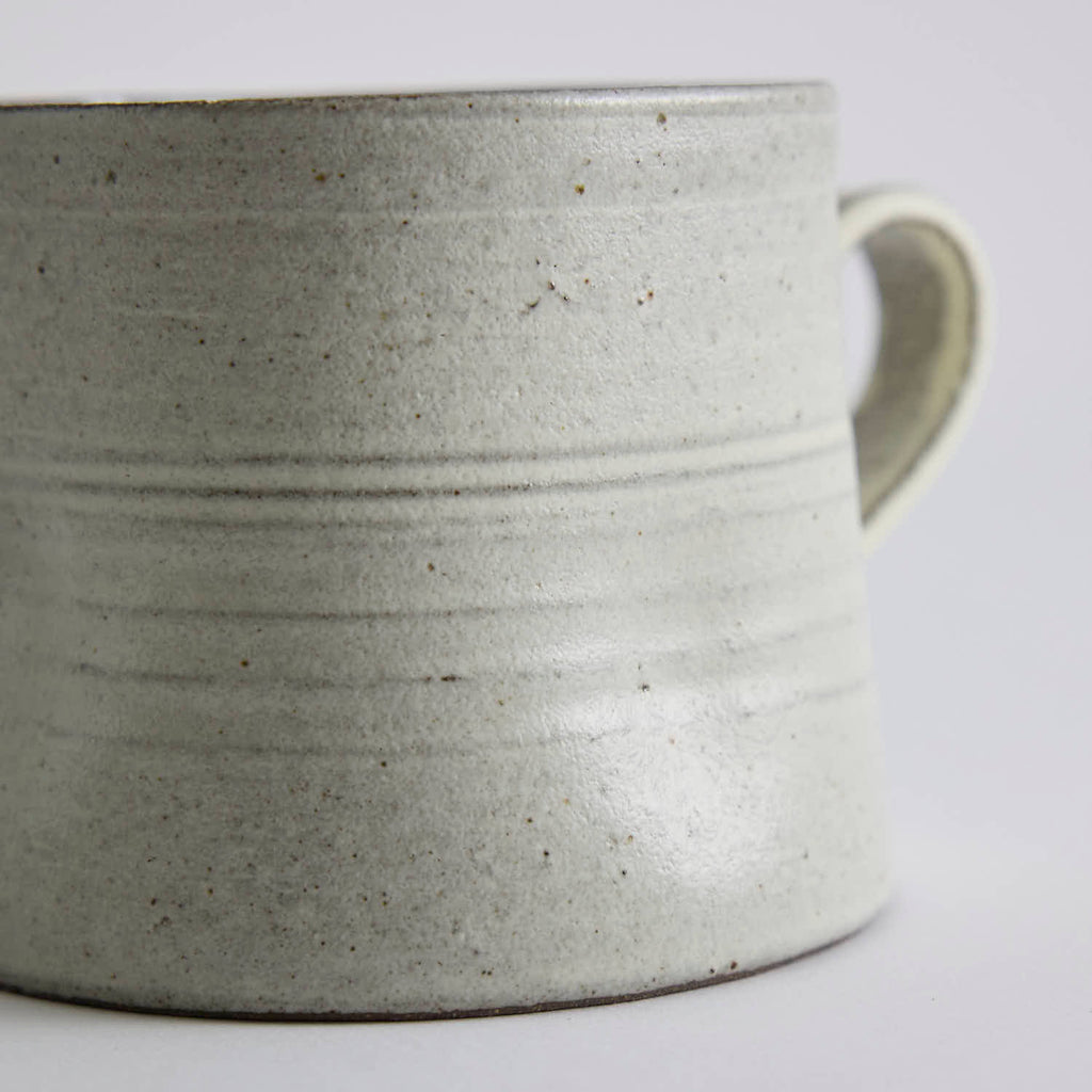 Handcrafted kiln-varied coffee cup with square rim and natural speckled texture
