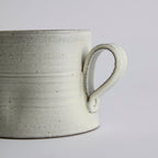 Handcrafted kiln-varied coffee cup with square rim and natural speckled texture