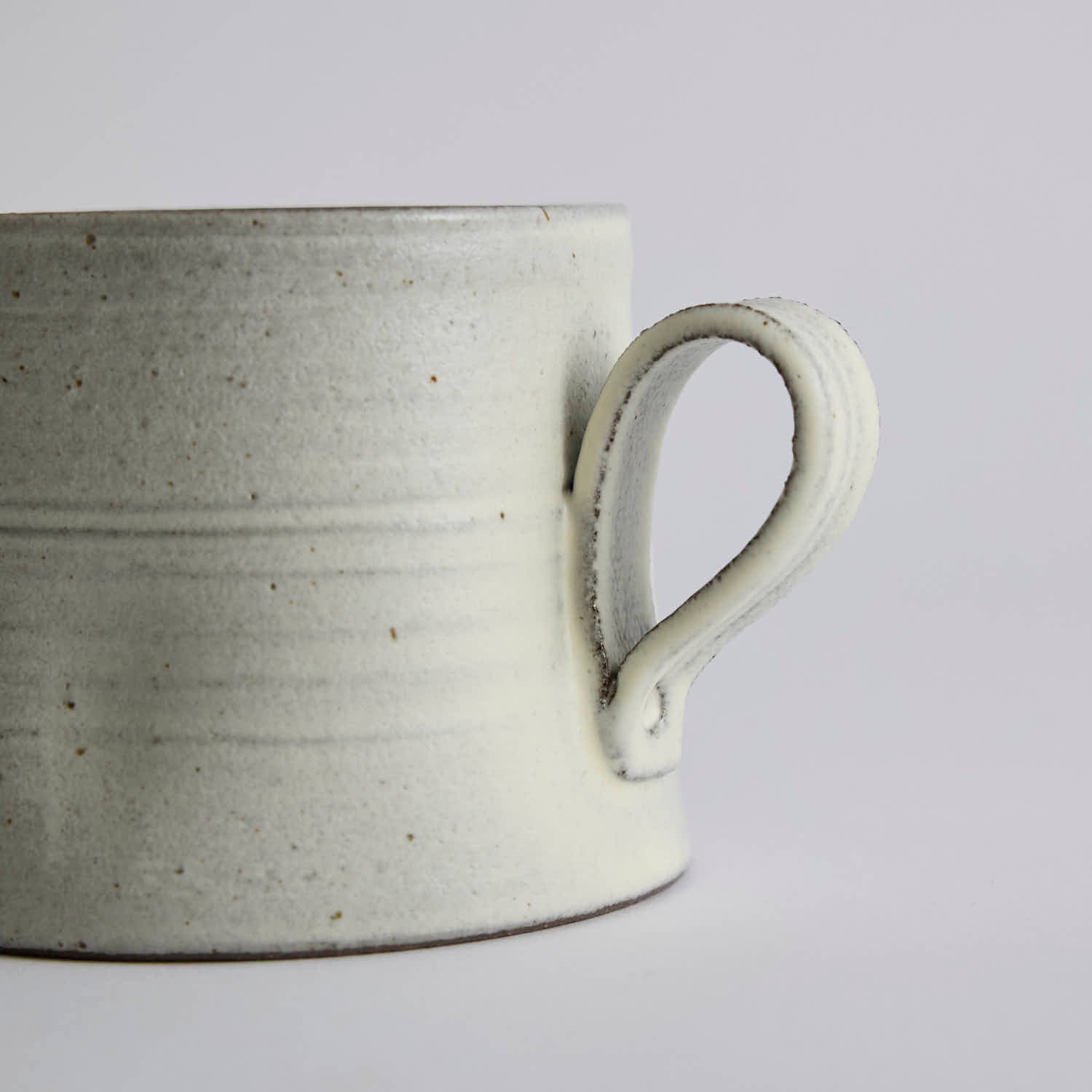 Handcrafted kiln-varied coffee cup with square rim and natural speckled texture