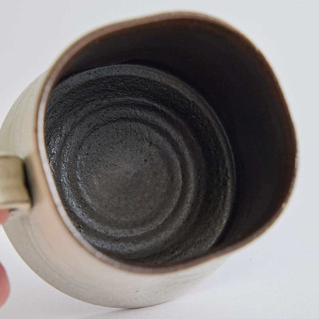 Handcrafted kiln-varied coffee cup with square rim and natural speckled texture