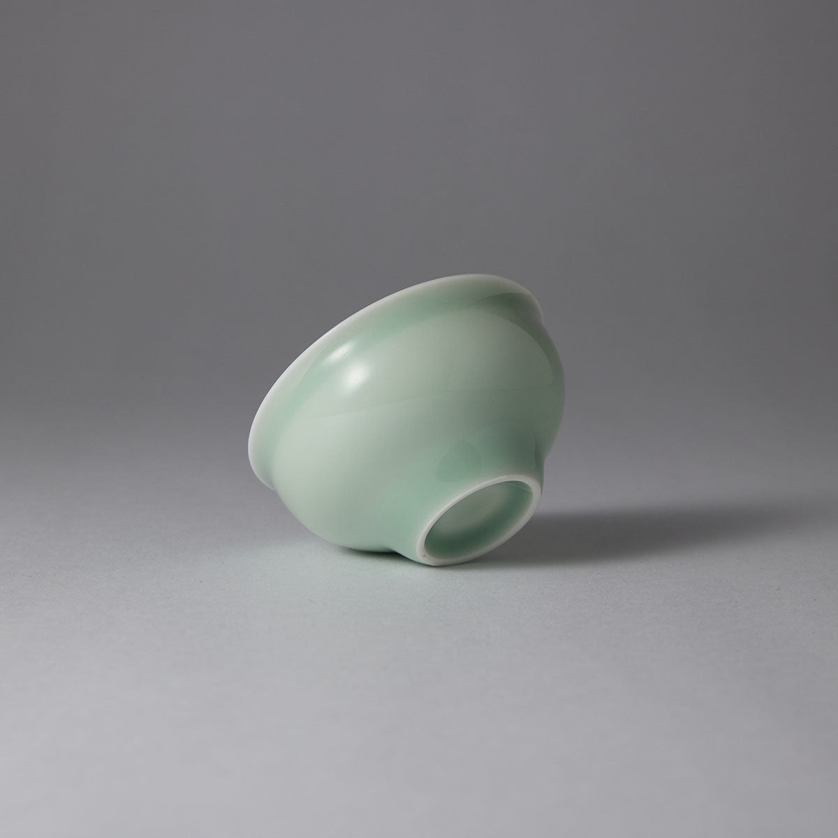 Ou Kiln open-rim celadon teacup with a smooth jade-like glaze and minimalist bowl-shaped design.