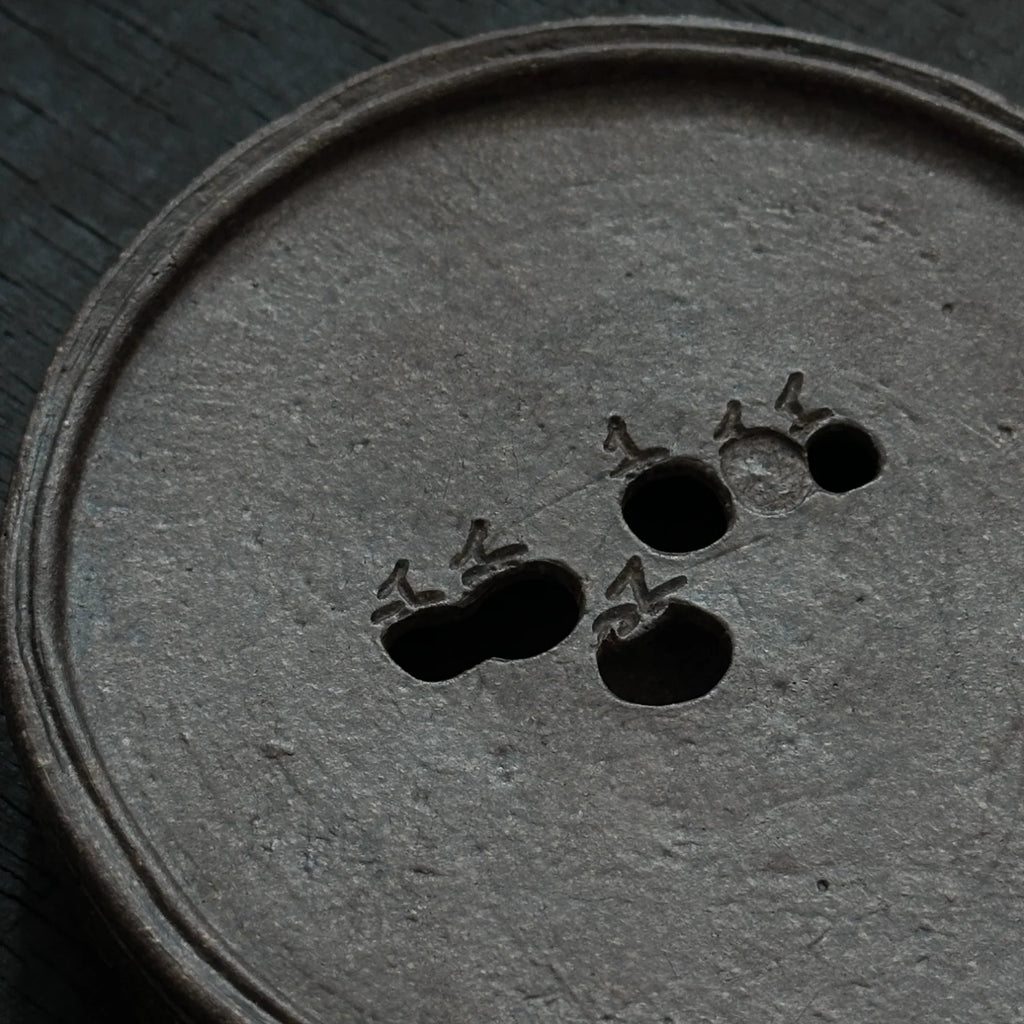 Handmade teapot stand with a persimmon design that can hold water.
