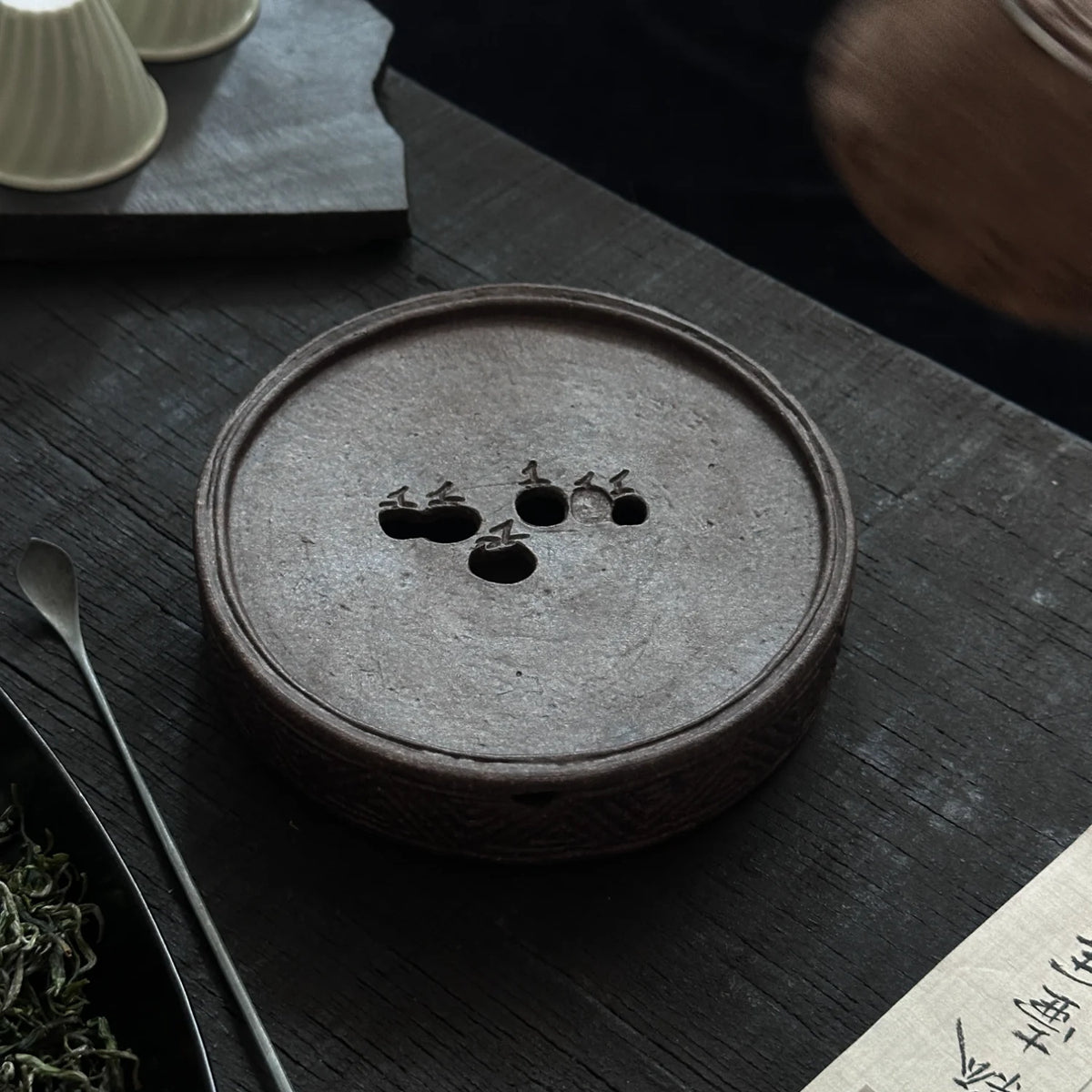 Handmade teapot stand with a persimmon design that can hold water.